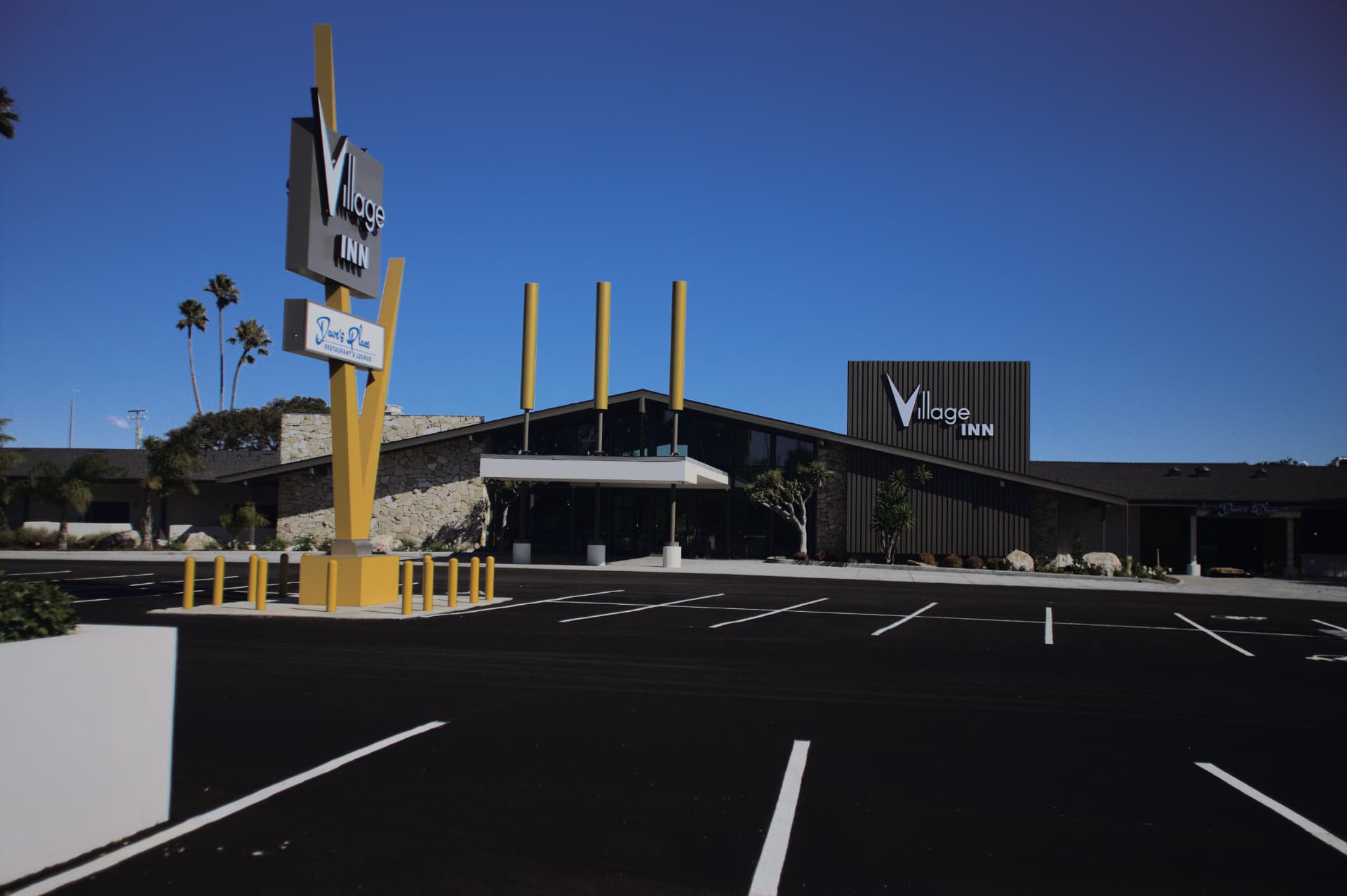 Mid-century Village Inn sign against a deep blue sky